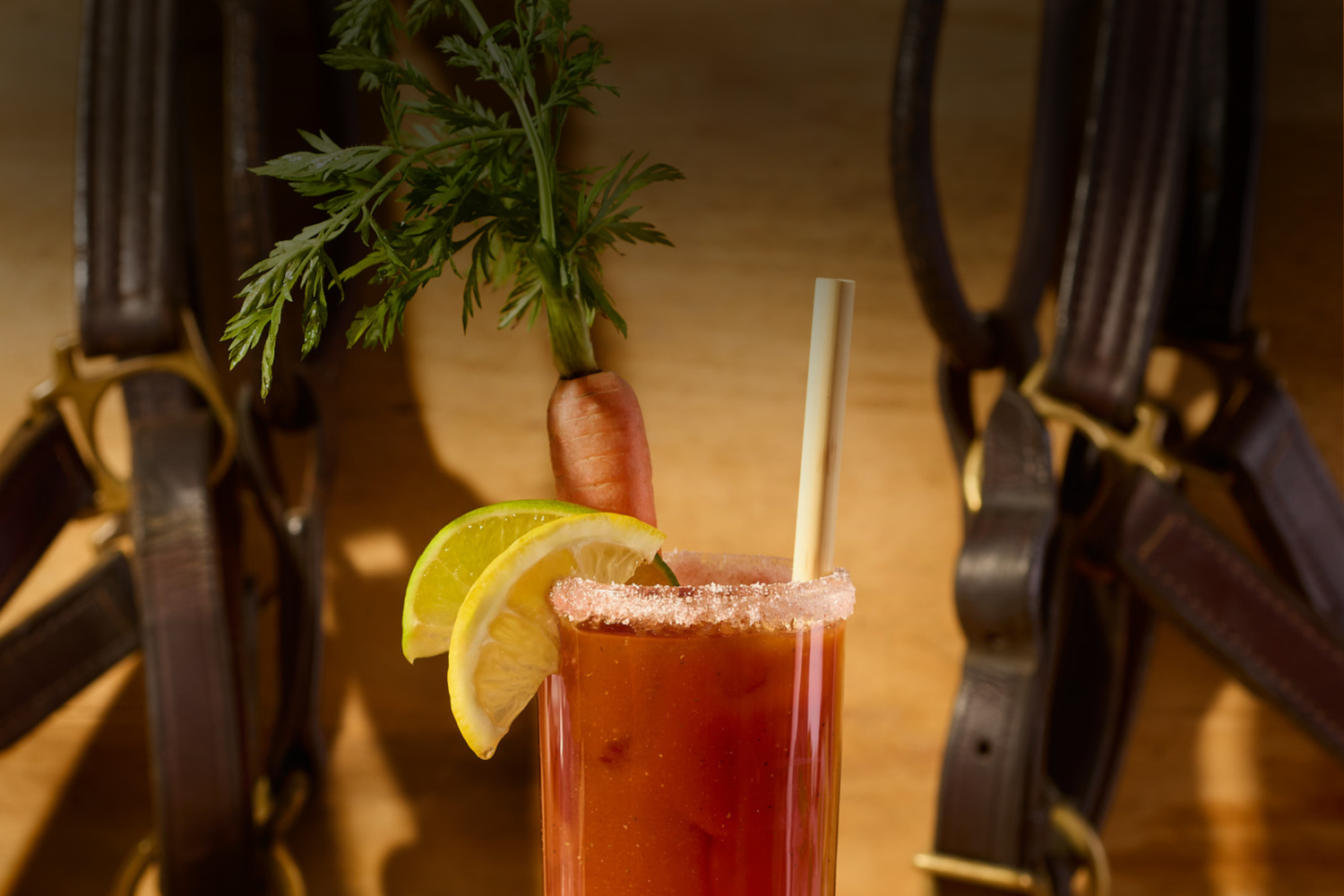  Bloody Mary cocktail with lemon wedge and carrot stick garnish on a wooden background